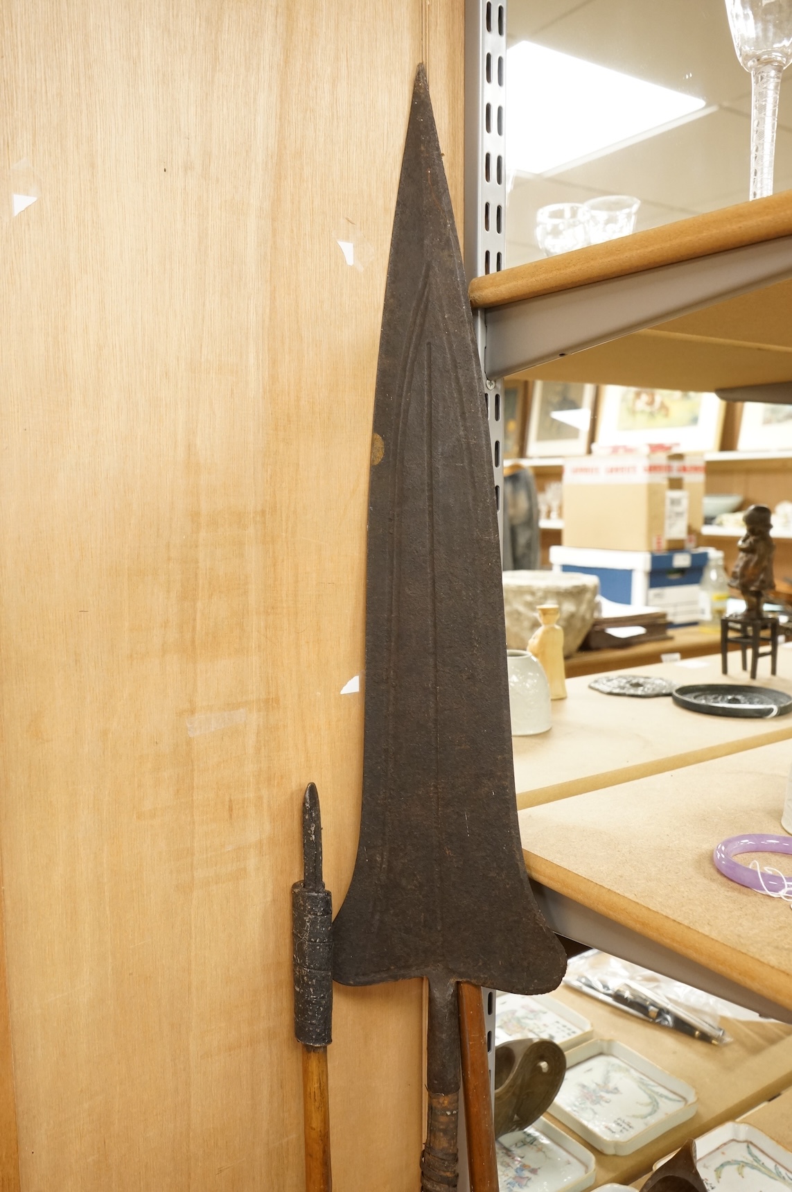 A collection of tribal spears, a fish hook, a cased snooker cue, etc.